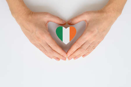 The national flag of Ireland in female hands. The concept of patriotism, respect and solidarity with the citizens of Ireland.の写真素材