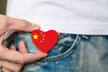 Patriot of the Republic of China! Wooden badge with China flag in the shape of a heart in a man's hand.の写真素材