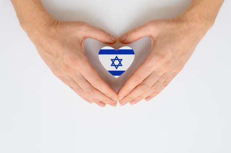 The national flag of Israel in female hands. The concept of patriotism, respect and solidarity with the citizens of Israel.の写真素材