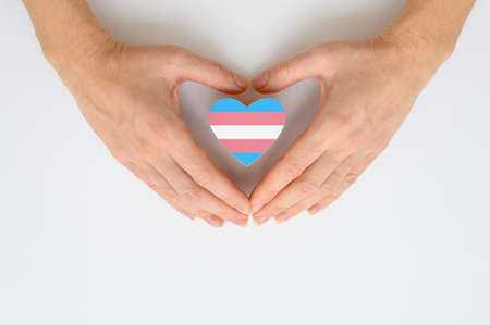 Respect for transgender people. Transgender flag in hands not against white background.の写真素材