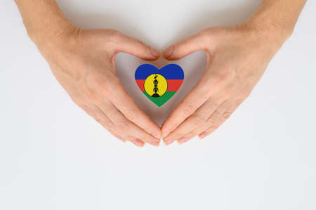 The national flag of New Caledonia in female hands.の写真素材