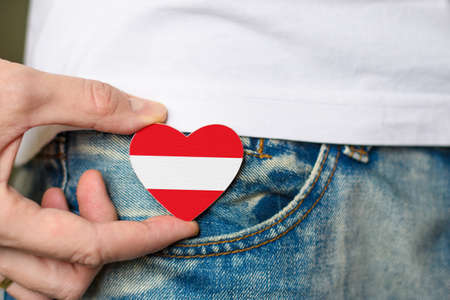 Patriot of the Austria! Wooden badge with Austria flag in the shape of a heart in a man's hand.の写真素材