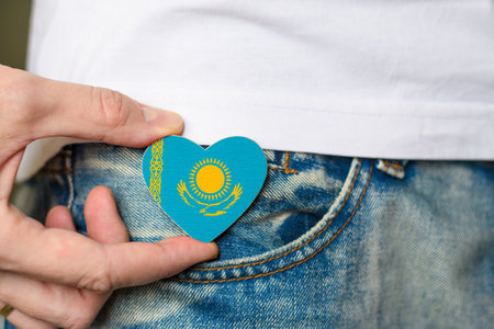 Patriot of the Kazakhstan! Wooden badge with Kazakhstan flag in the shape of a heart in a man's hand.の写真素材
