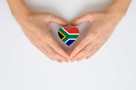 The national flag of South Africa in female hands. The concept of patriotism, respect and solidarity with the citizens of South Africa.の写真素材