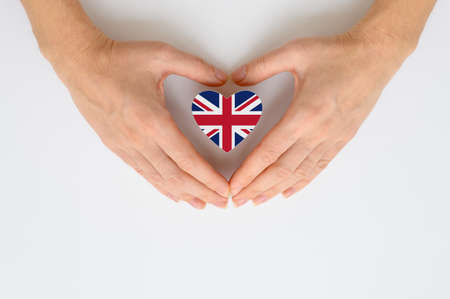 The national flag of Great Britain in female hands. The concept of patriotism, respect and solidarity with the citizens of the United Kingdom.の写真素材