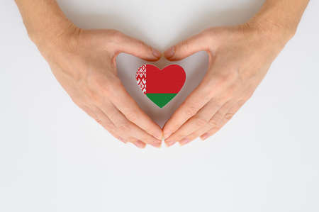 The national flag of Belarus in female hands. The concept of patriotism, respect and solidarity with the citizens of Belarus.の写真素材