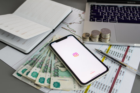 Vladimir, Russia - January 2022: Smartphone with open Instagram application on Russian money. The concept of earning bloggers in Russia. Selective focus on the logo.のeditorial素材