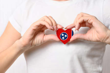 Flag of the State of Tennessee in the shape of a heart in the hands of a girl. Love Tennessee. The concept of patriotismの写真素材