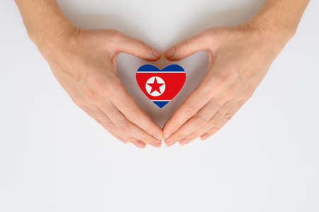 The national flag of North Korea in female hands. The concept of respect and solidarity with the citizens of North Korea.の写真素材