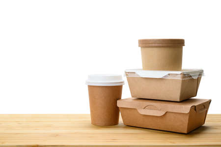Several paper containers for food delivery on a wooden table. Isolated white background. Template...