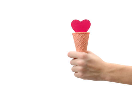 Heart in an ice cream cone in hand on a white background. isolated object.の写真素材