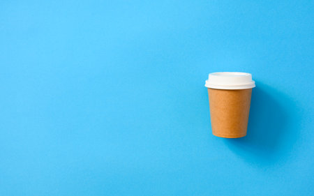 Paper disposable cup on a blue background. Use of eco-friendly tableware. food delivery. Flat lay, copy space.の写真素材