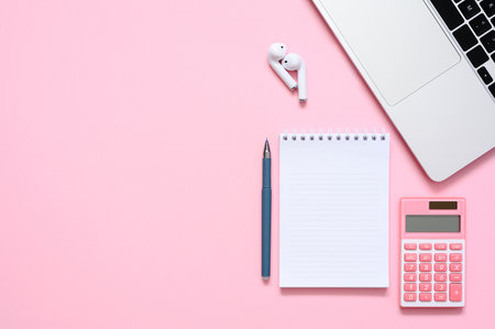 Notepad, calculator and laptop on a pink background. view from above. The concept of planning expenses or income.の写真素材