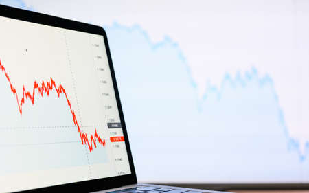 Financial declining graphs on monitors during the crisis. Graphs on a light background. Selective focus on near monitor, blurry background.の写真素材