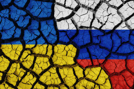 Flag of Ukraine and Russia on the texture of the cracked dry earth. The concept of conflict between statesの写真素材