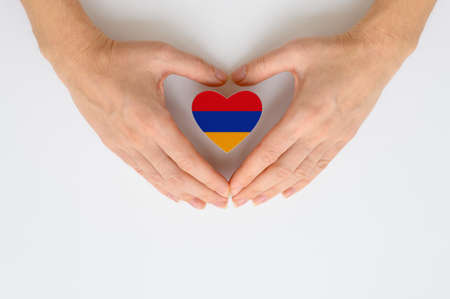 The national flag of Armenia in female hands. The concept of patriotism, respect and solidarity with the citizens of Armenia.の写真素材