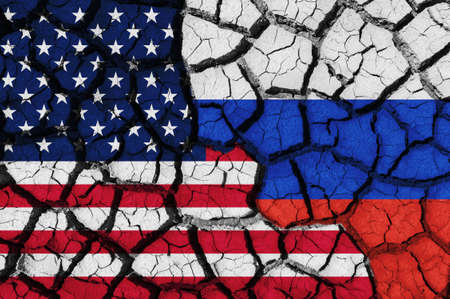 Flag of the United States (USA) and Russia on the texture of the cracked dry earth. The concept of conflict between statesの写真素材
