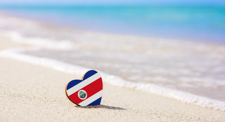 Flag of the Costa Rica in the shape of a heart on a sandy beach. The concept of the best vacation in Costa Ricaの写真素材