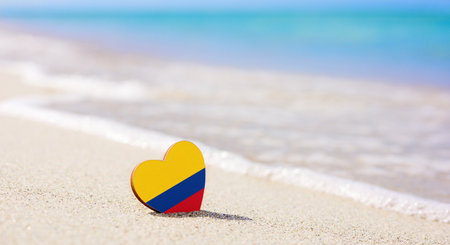 Flag of the Colombia in the shape of a heart on a sandy beach. The concept of the best vacation in Colombiaの写真素材