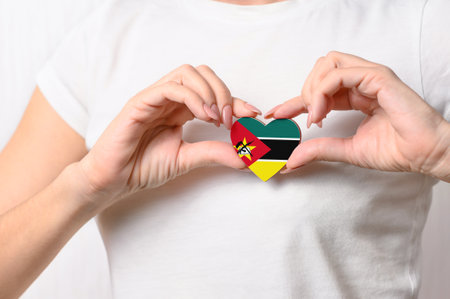 Flag of Mozambique in the shape of a heart in the hands of a girl. Love Mozambique. Respect for the people of Mozambiqueの写真素材