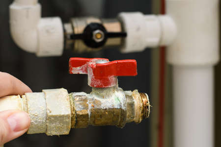 Plumbing old water faucet covered with lime and scale against the background of a new plumbing. The problem of poor-quality water supply in residential buildings.の写真素材