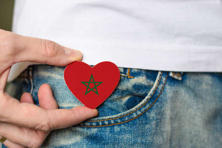 Patriot of the Morocco! Wooden badge with Morocco flag in the shape of a heart in a man's hand.の写真素材