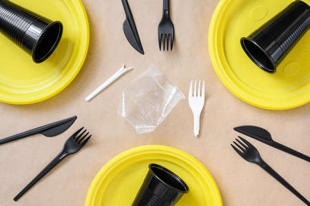 Plastic new disposable tableware and plastic waste. The concept of danger from the use of plasticの写真素材