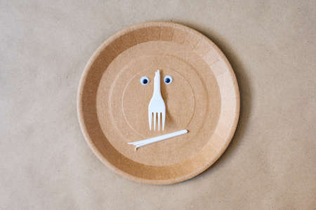 An angry expression made out of plastic trash on a disposable paper plate. environmental pollution conceptの写真素材