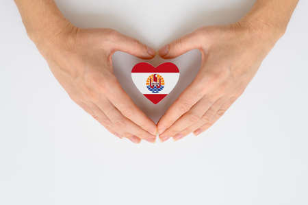 Flag of French Polynesia in the shape of a heart in female handsの写真素材
