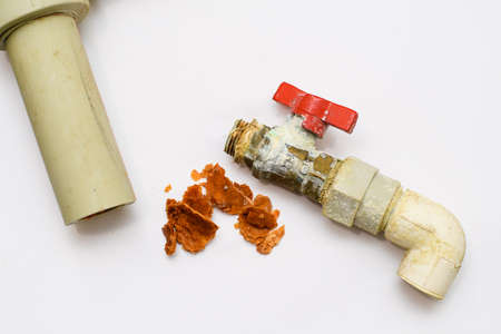 Repair of an old plumbing. Old polypropylene pipe, old ball valve and rusty pipe debris on a white background.の写真素材