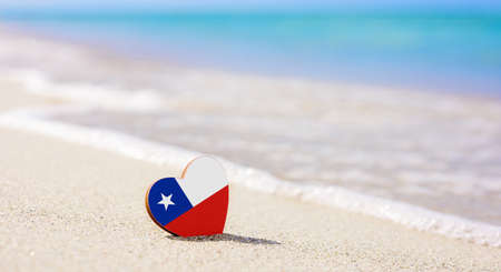 Flag of Chile in the shape of a heart on a sandy beach. The concept of the best vacation in Chile resorts.の写真素材