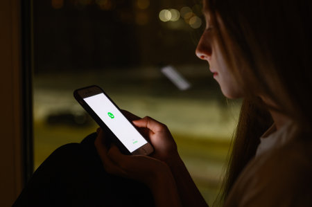 Vladimir, Russia - January 2022: Using Whatsapp messenger for communication. Smartphone in hand with an application. Selective focus on the logo.のeditorial素材
