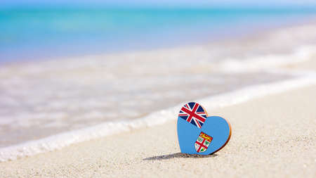 Flag of the Fiji in the shape of a heart on a sandy beach. The concept of the best vacation in Fiji resortsの写真素材