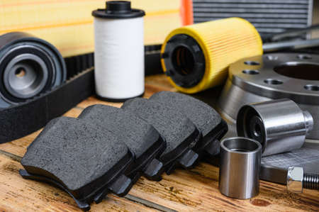 New car parts on a wooden table. Selective focus on brake pads. Car maintenance and repair conceptの写真素材