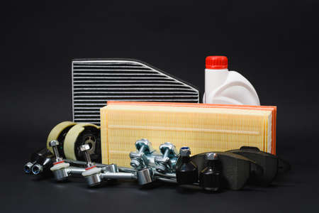 New car parts on a dark background. Filter, coolant, brake pads on a black background.の写真素材