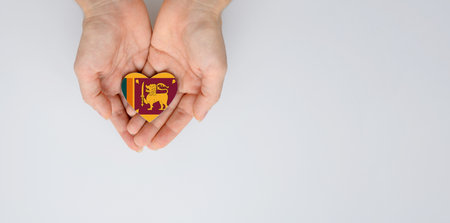 The national flag of Sri Lanka of arms in female hands. Flat lay, copy space.の写真素材