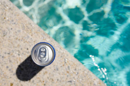A can of cold drink by the pool in a hotel on a hot day. Top view, selective focus on the bank.の写真素材
