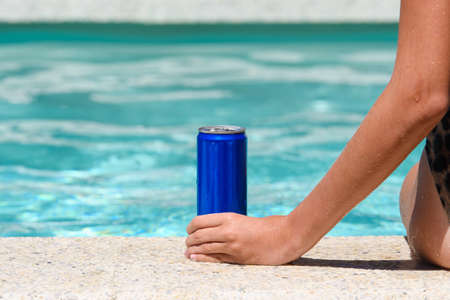 Girl by the pool with a can of cold drink. close-up. summer vacation conceptの写真素材