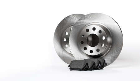 New brake discs and pads stand on a white background. copyspace.
