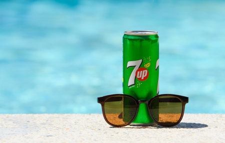 Novorossiysk - Russia, July 2022: 7up cold drink can and sunglasses by the pool on a summer day.