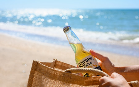 Anapa - Russia, August 2022: A girl on the beach takes out a bottle of Corona Extra beer from her...