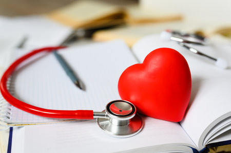 Red heart on books and phonendoscope. Selective focus on heart and phonendoscope. Concept of medical literatureの写真素材