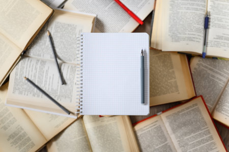 Educational notebook with a pen on the background of open books. Empty blank sheet. copyspace.の写真素材