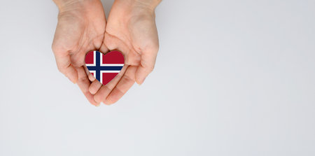 The national flag of Norway in the shape of a heart in the hands. Flat lay, copy space.の写真素材