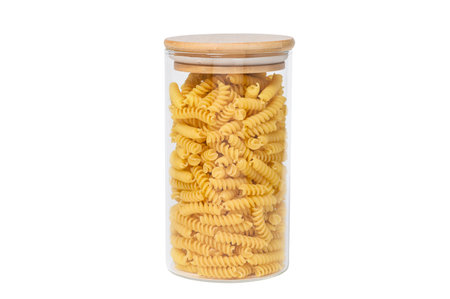 Glass jar with pasta on a white isolated background. fusilli pasta.の写真素材