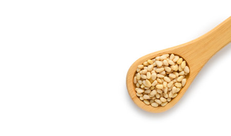 Wooden spoon with pine nuts on a white background. Top view, copy space. healthy food conceptの写真素材