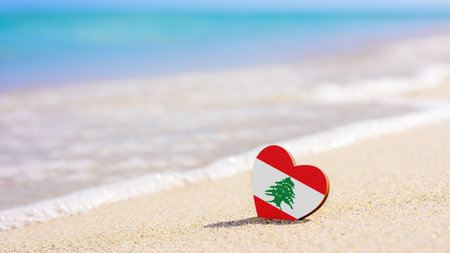 Flag of Lebanon in the shape of a heart on a sandy beach. The concept of the best vacation in Lebanon resortsの写真素材