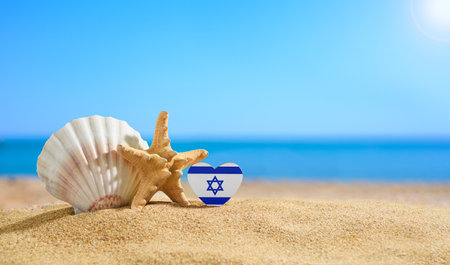 Beautiful beach in Israel. Flag of Israel in the shape of a heart and shells on a sandy beach.の写真素材