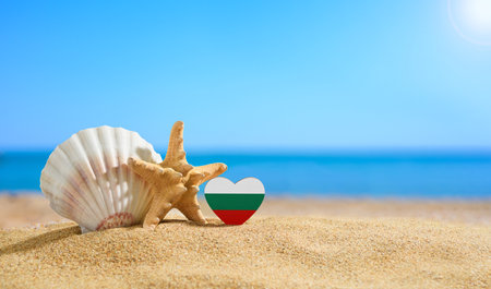 Beautiful beach in Bulgaria. Flag of Bulgaria in the shape of a heart and shells on a sandy beach.の写真素材