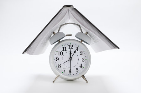 The book on the alarm clock. The concept of reading and education.